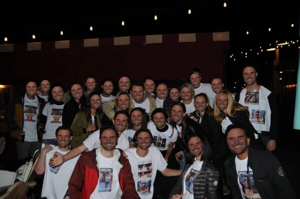 Airbnb coworkers holding cutouts of Tommy's face at his farewell